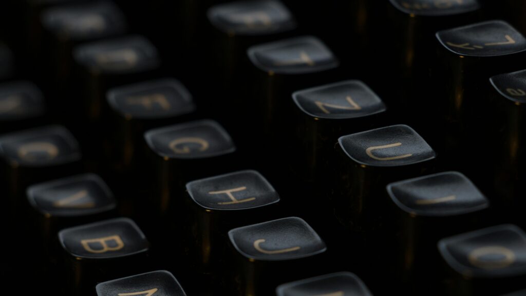 Artistic close-up of vintage typewriter keys highlighting letters with a shallow depth of field.