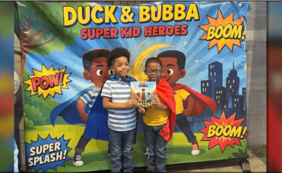 screenshot from video - superhero siblings pose with their new book