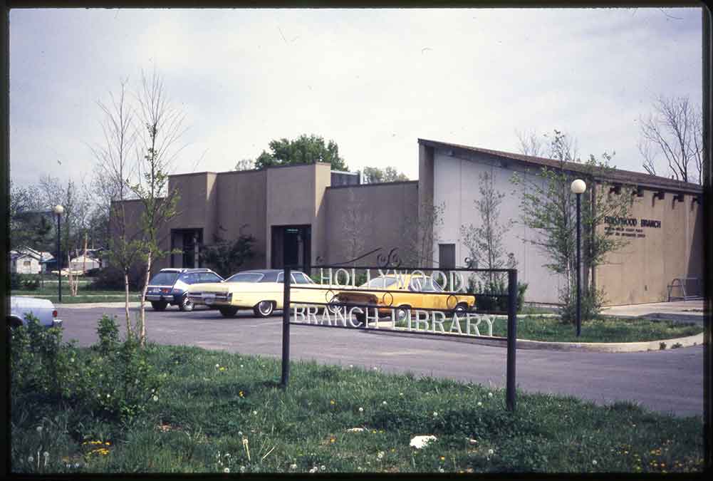 Image showing Hollywood Branch Library with a sign that reads "Hollywood Branch Library" in the foreground. In the background we saw cars parked in the library parking lot.