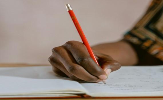cloud up image of a hand writing in a notebook