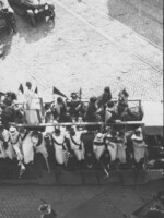 Women holding flags, on a float in the suffrage parade.