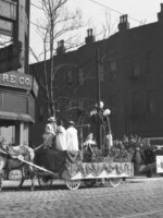 Suffrage parade in front of Leo Kahn Furniture Company on Main Street next to the Chisca, at the corner of Main and Pontotoc Avenue. The parade pictured here is likely the suffrage parade held on March 29, 1916 to mark a major suffrage meeting and visit by national leader Mrs. Carrie Chapman Catt. The parade is described in the Commercial Appeal as beginning on Main at Pontotoc, with floats and groups assembled on Pontotoc, facing Main Street. Additionally, the article describes the parade's floats and a "'Map of the United States' showing the states that have full suffrage, those with partial suffrage and those which do not have suffrage". This map is visible on the right side of the photograph.
