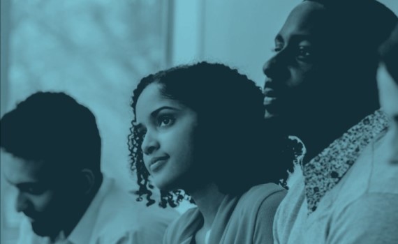 a group of people listening to a presentation