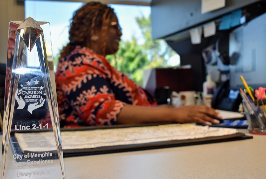 Kimberly Jordan-Fluker works from her desk at LINC 211 gleefully gazing at her computer desktop.